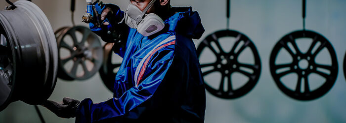 Man spraying paint on an alloy wheel