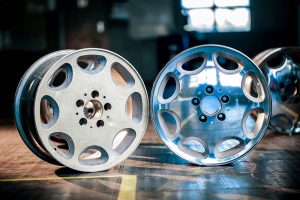 A before and after image of a refurbished alloy wheel