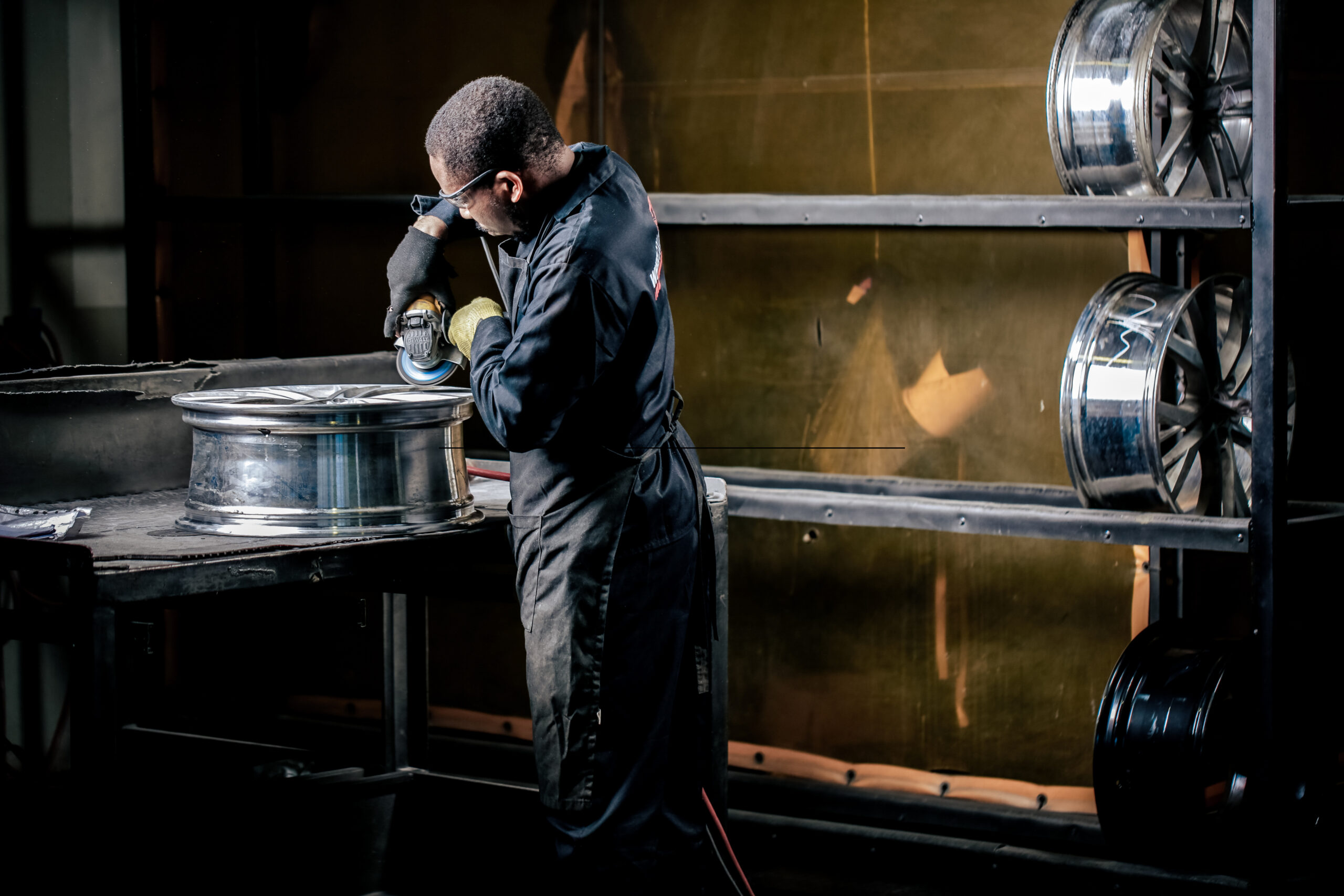 Wheel Repair Specialist using a machine to refurbish an alloy wheel