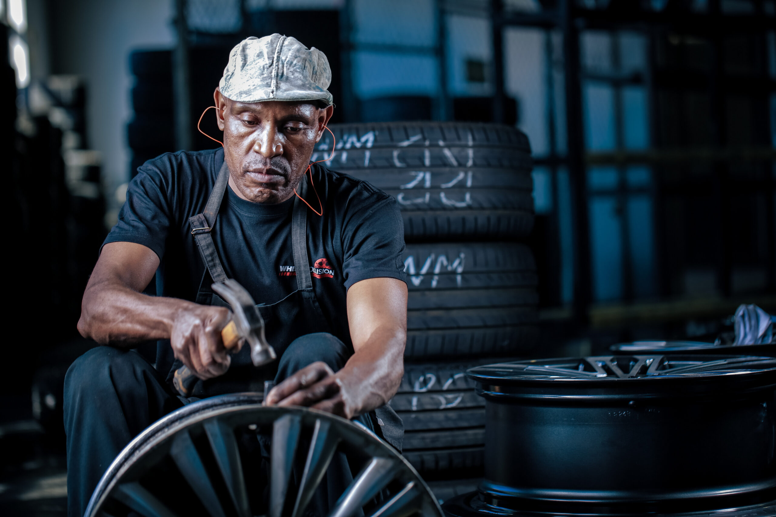 Man straightening an alloy wheel at the Wheel Collision refurbishment center